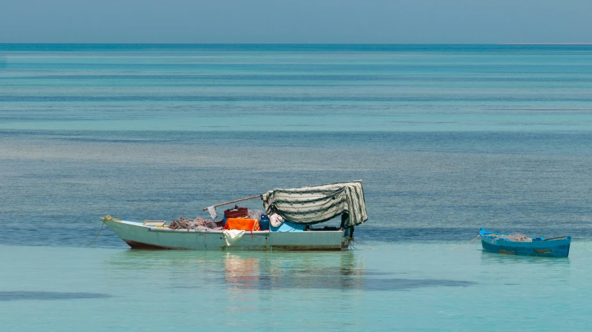 a boat on the sea with another row boat in the background