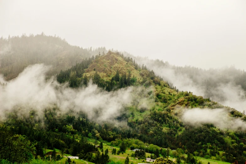 there are some clouds hanging over the hill