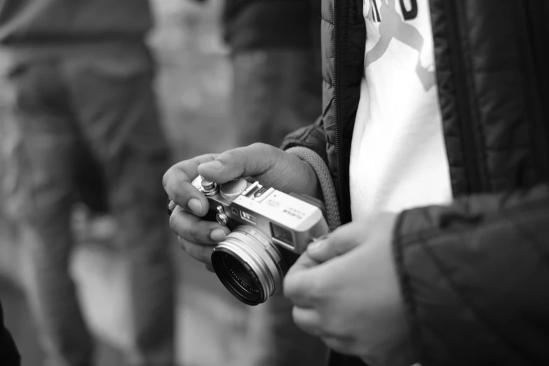 a person is holding a small silver camera