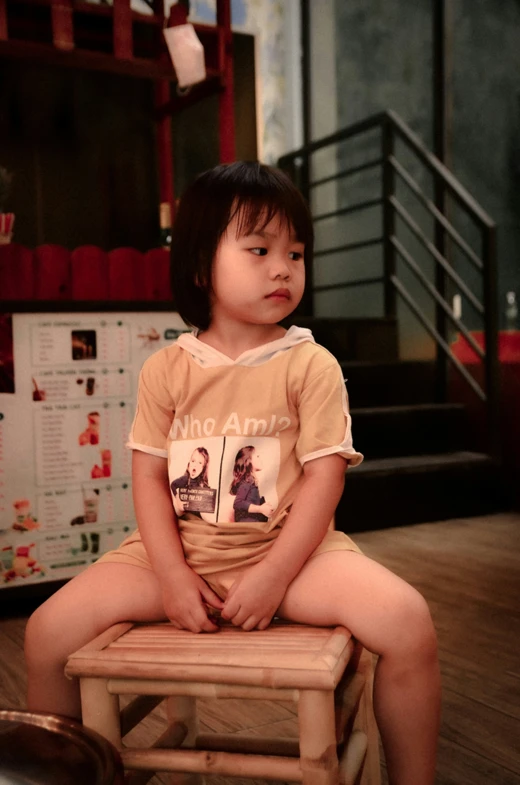 little girl sitting on a chair and posing for camera