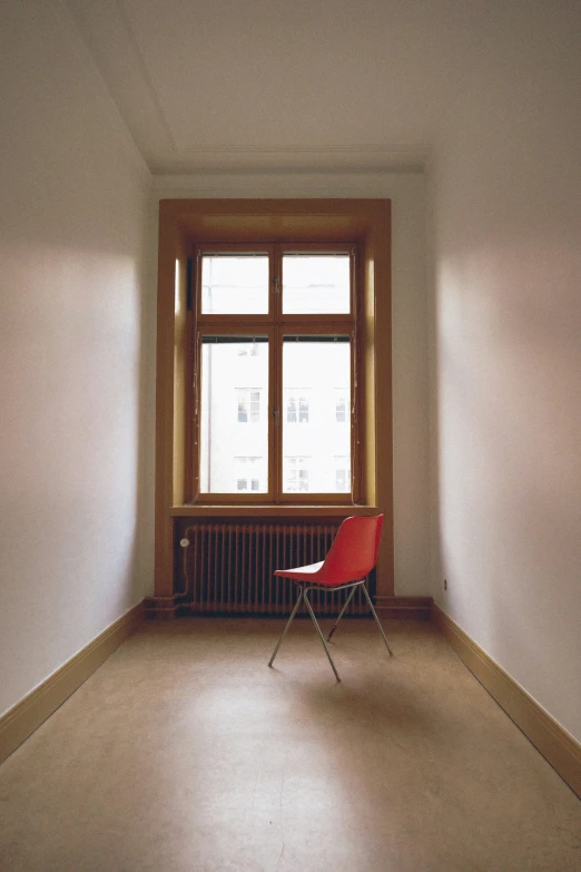 a chair sitting in front of a window on a bare floor