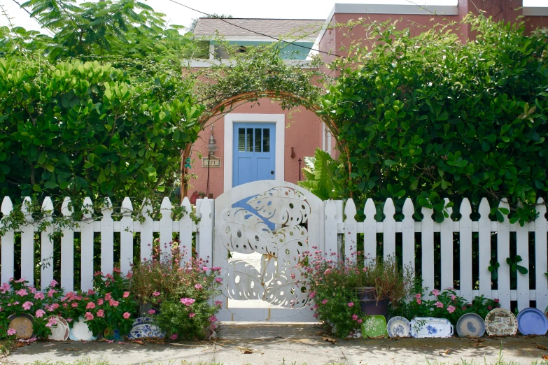 a white gate covered with lots of pink flowers