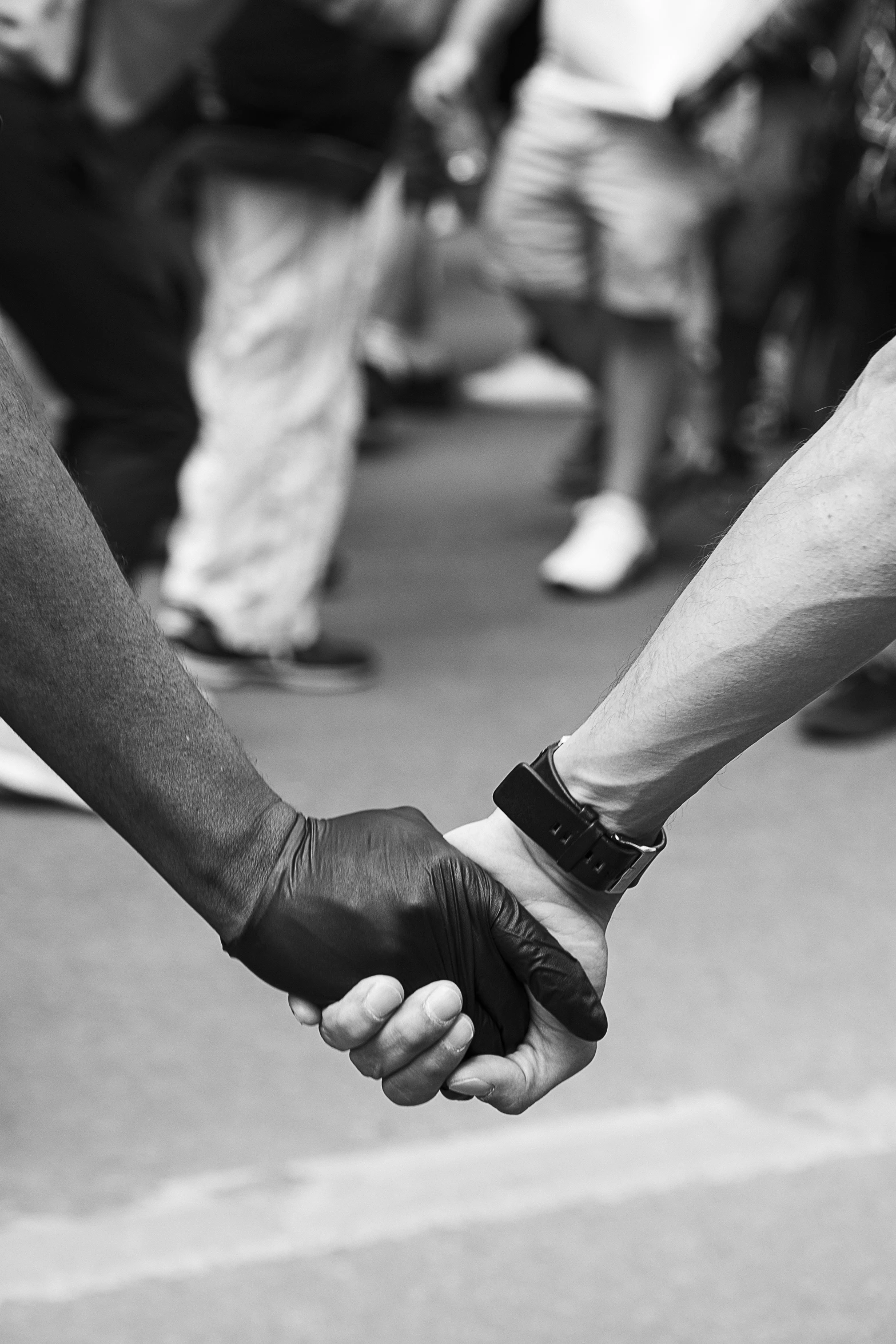 two people holding hands while standing on a street