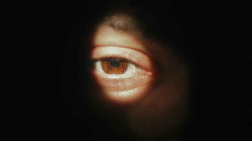 the reflection of someone's eye in the dark