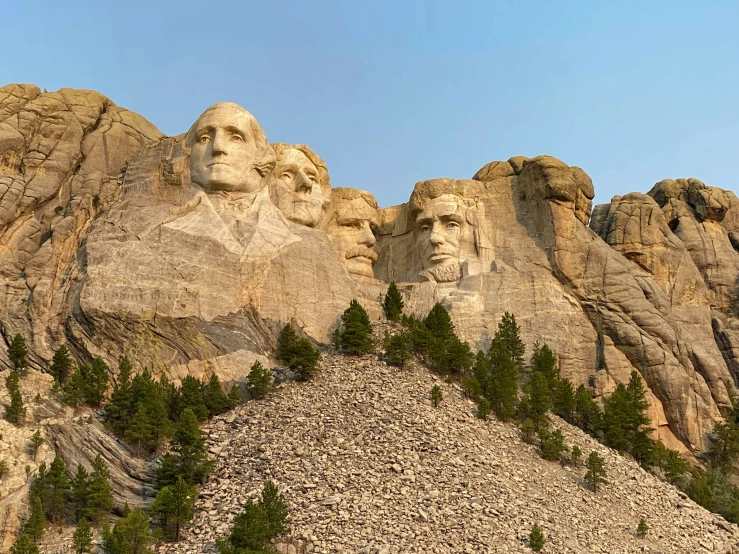 the mountain with many huge faces carved on it