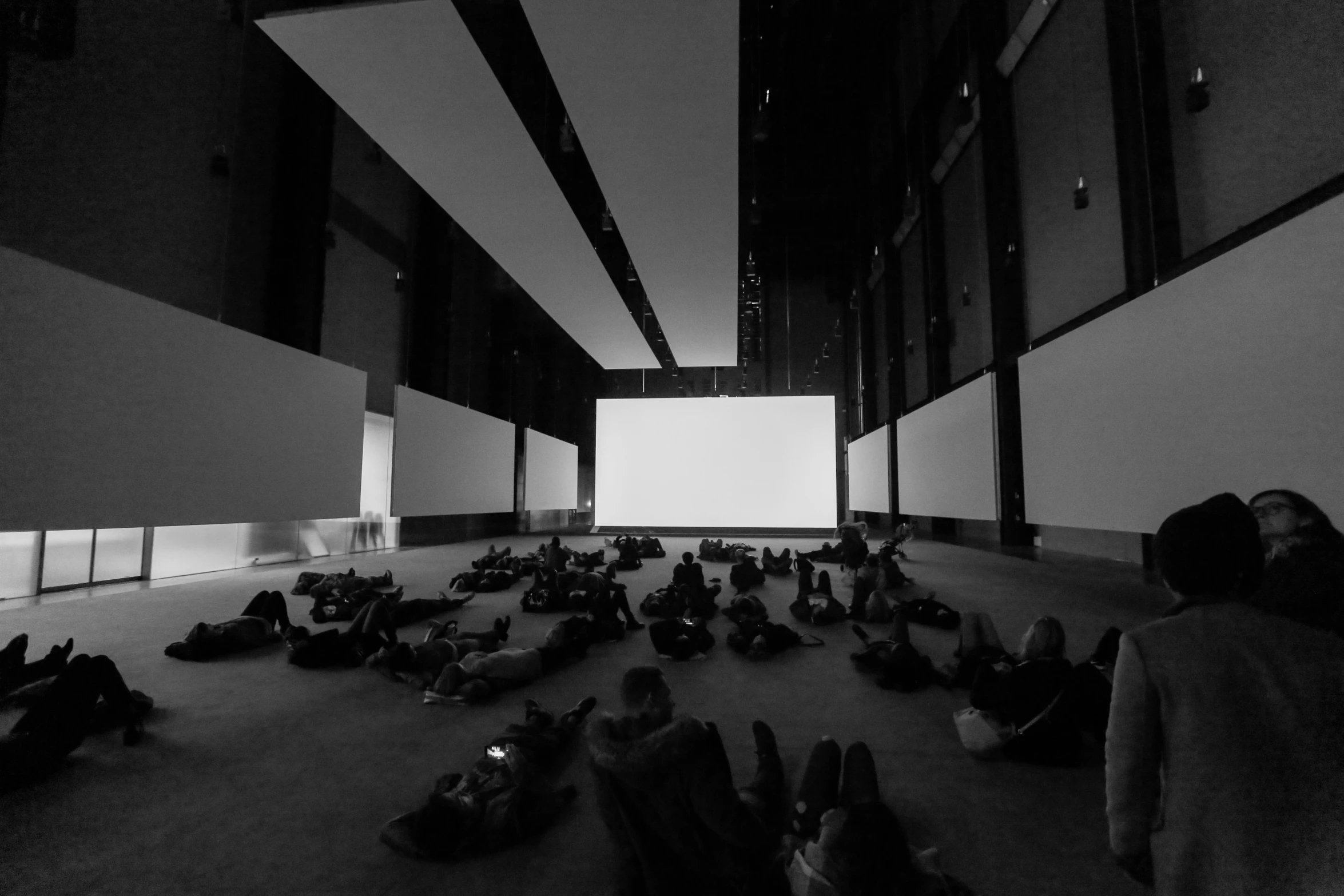 people lying down in the hall watching a movie