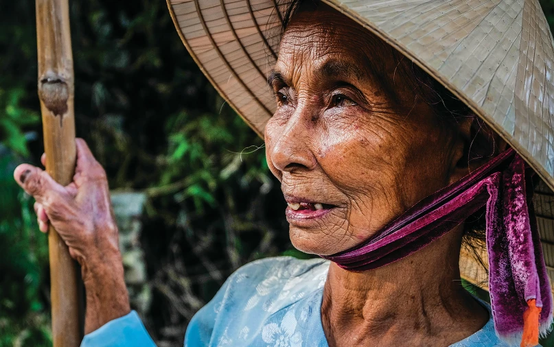 an old asian woman wearing a straw hat