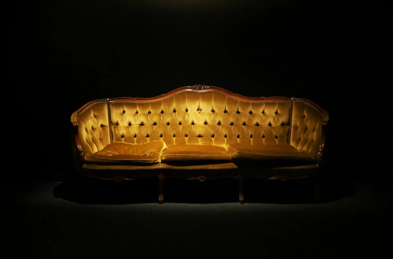 a couch sitting on top of a wooden table in the dark