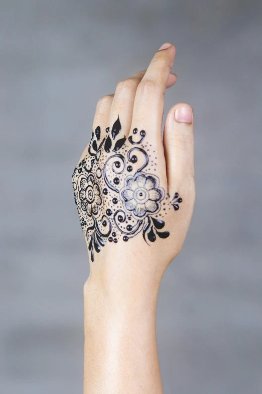 the tattoo on the woman's hand is intricately designed