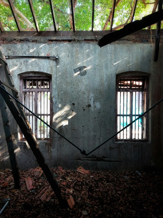 an abandoned building with several barred windows and a net