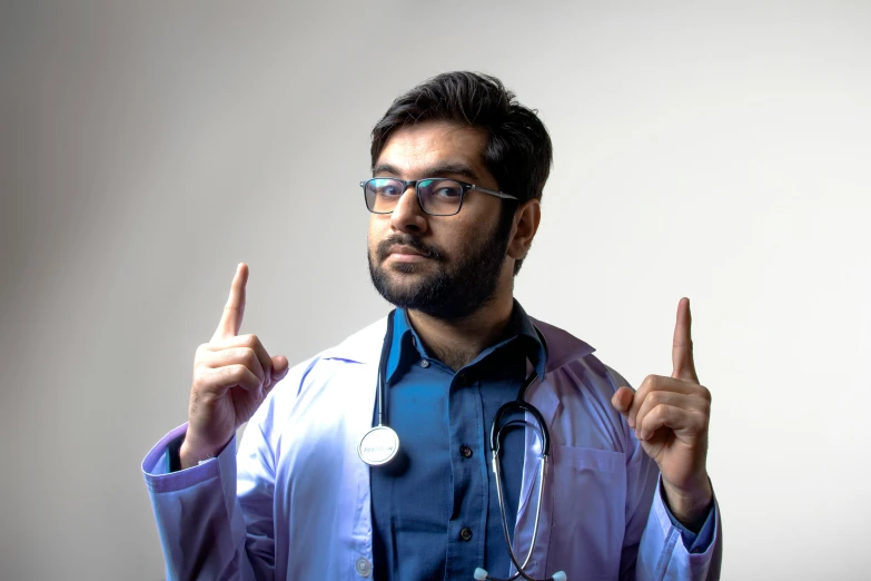 a man is wearing a doctors coat and making a sign