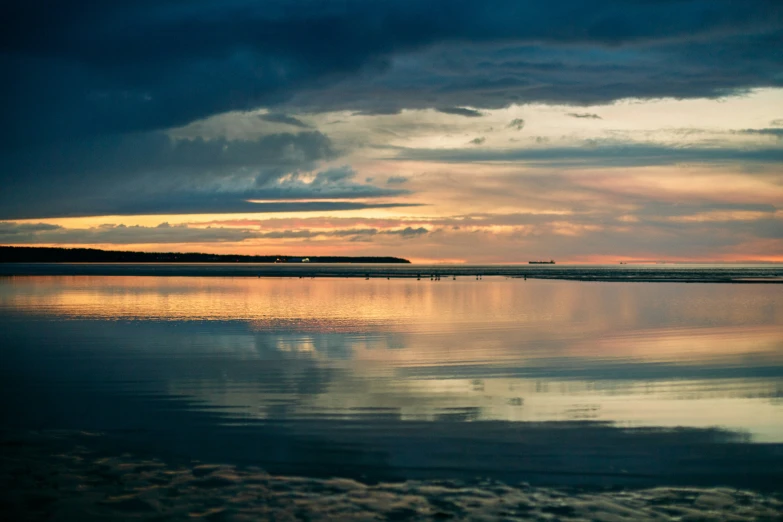 a dark and stormy sunset over a large body of water