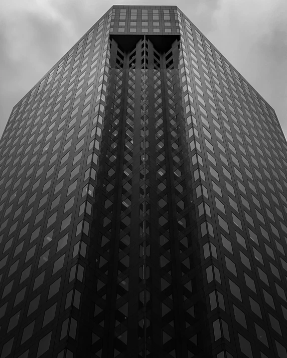 a tall building is seen from below with a sky line in the background