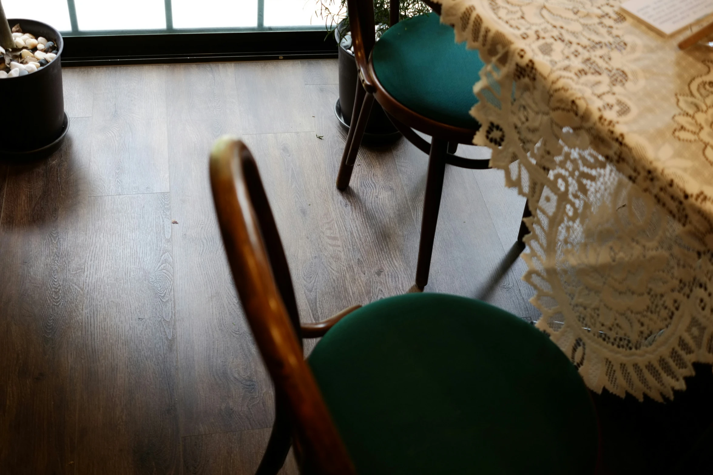 a green chair and white lace sitting at a table