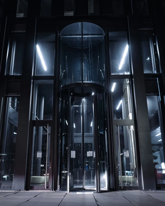 a huge, round glass building with a massive revolving door