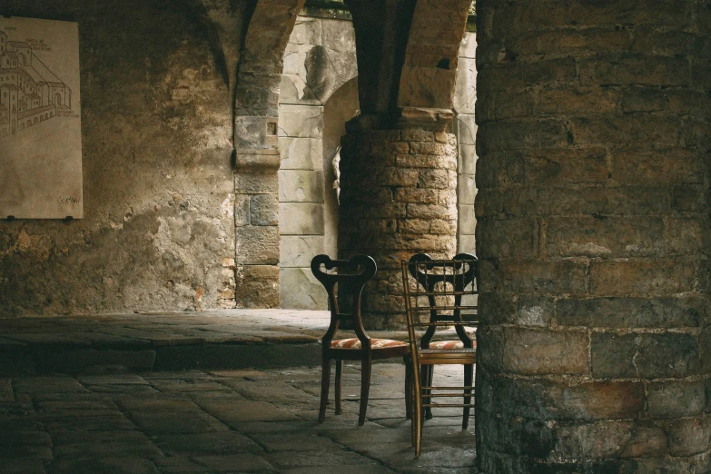 a chair and some pillars in an old building