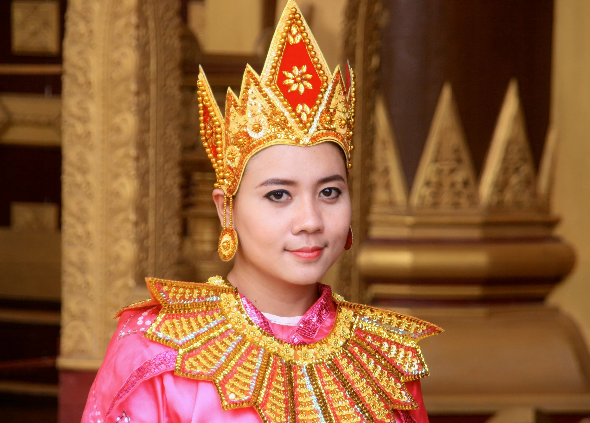 young man in gold and red costume standing in indoor setting