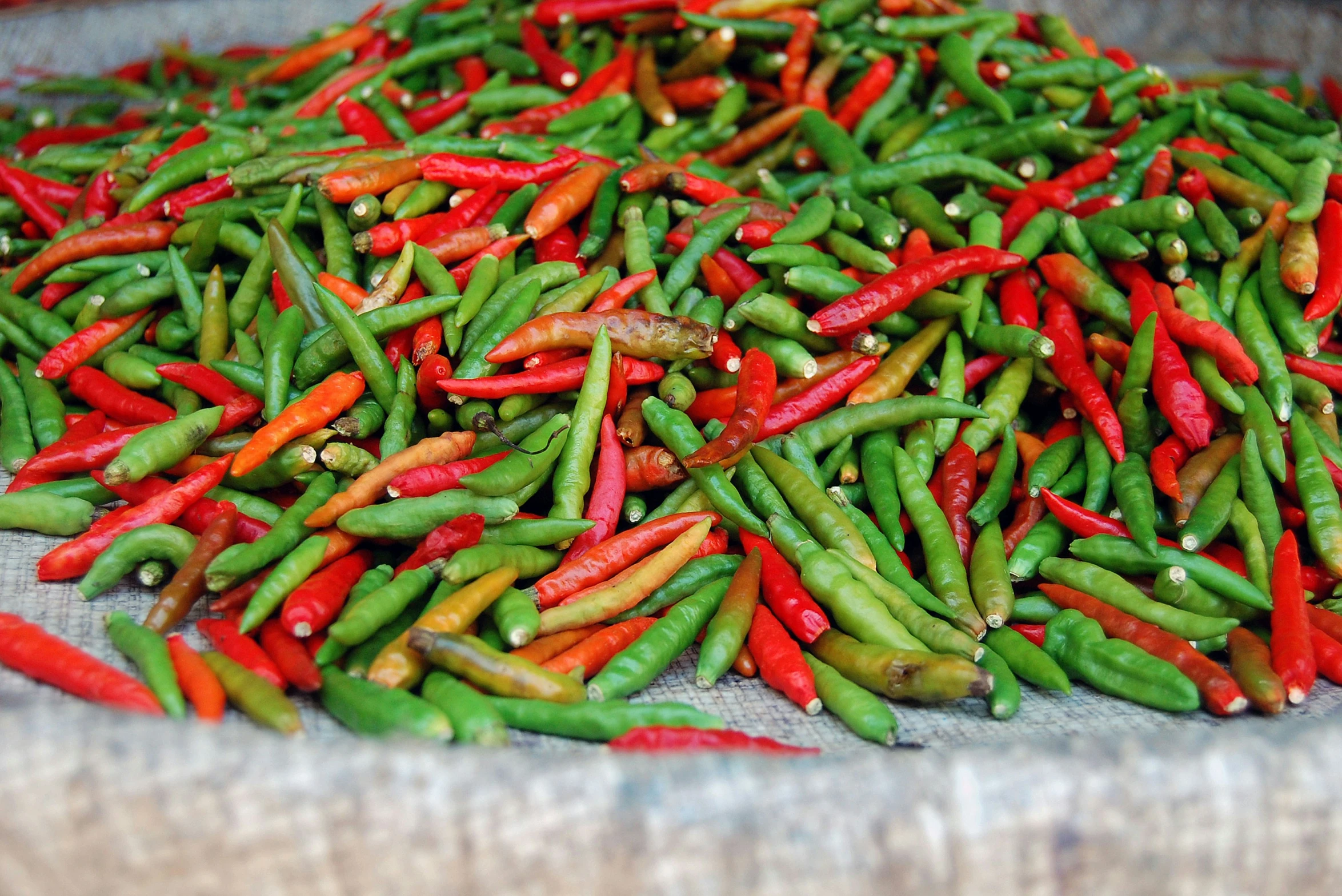 a pile of red and green peas on top of a cloth