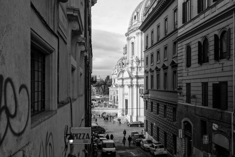 an alleyway leading to a building with people walking