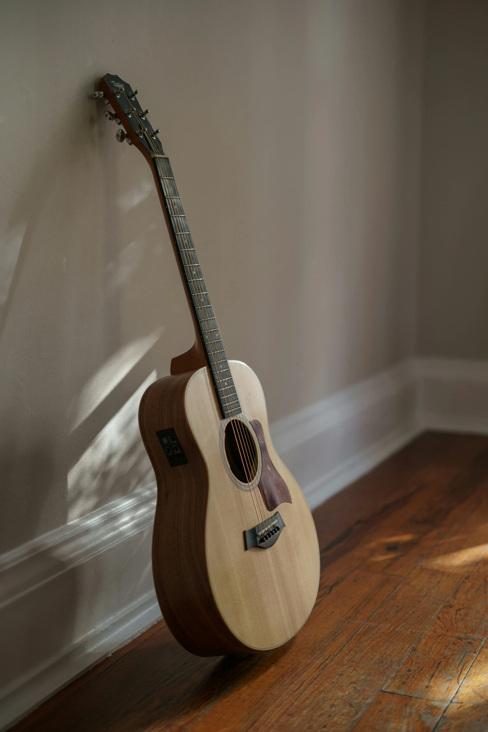 a guitar is propped against the wall