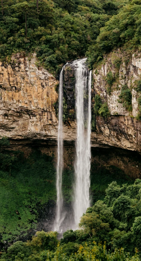 waterfall with green vegetation around it and another waterfall in the background