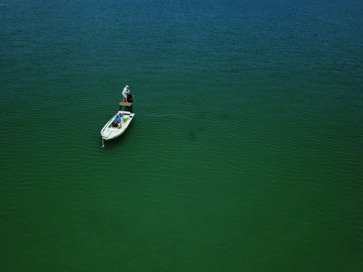 the man is rowing a boat with one leg in the water