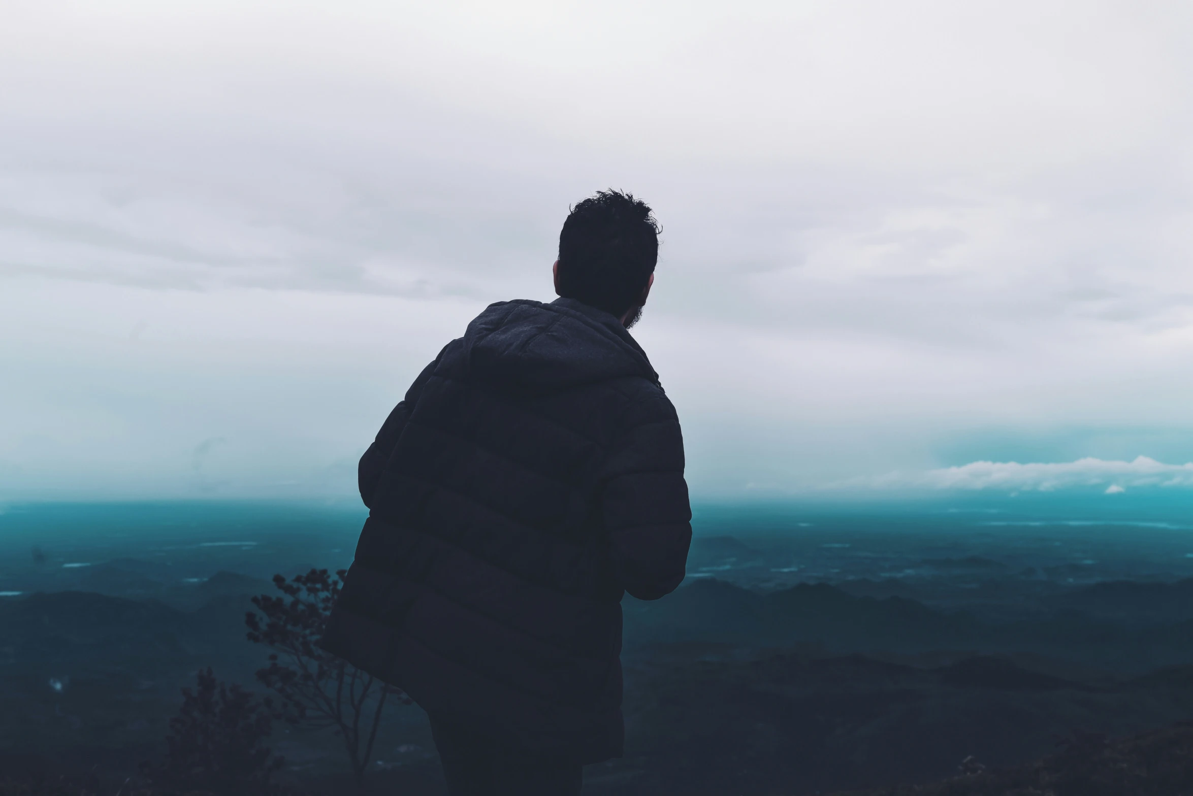 a man standing on a mountain looking at the sky