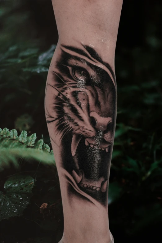 a tiger tattoo is on the leg of a young man