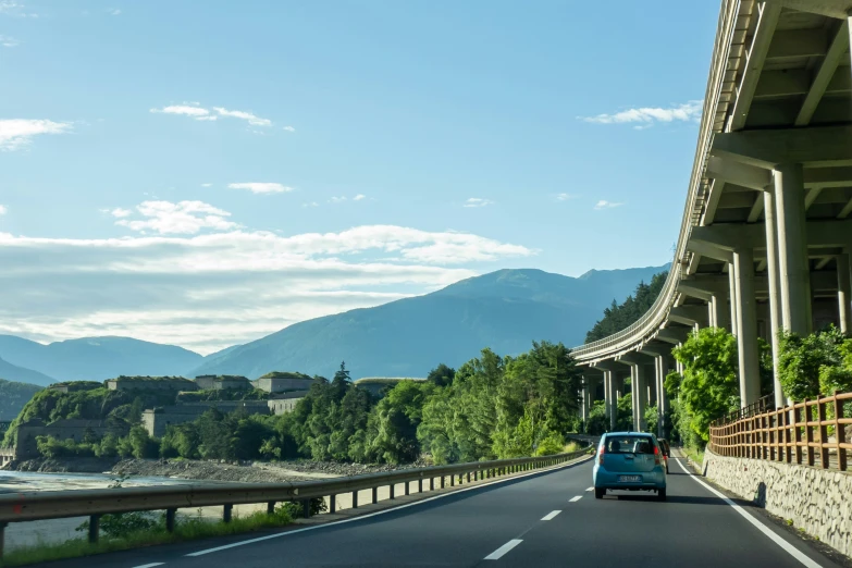 a van driving down the road with mountains behind it