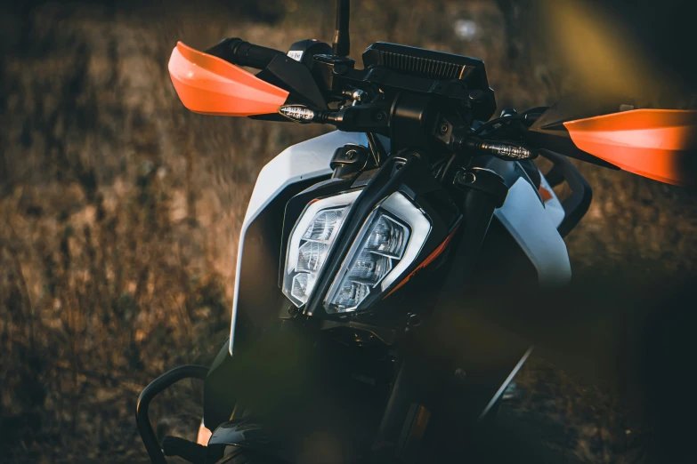 a motorcycle parked in the grass with its front light on