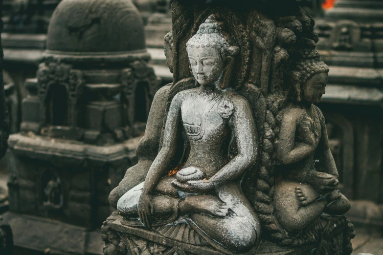 a gray statue sitting on top of a stone fountain
