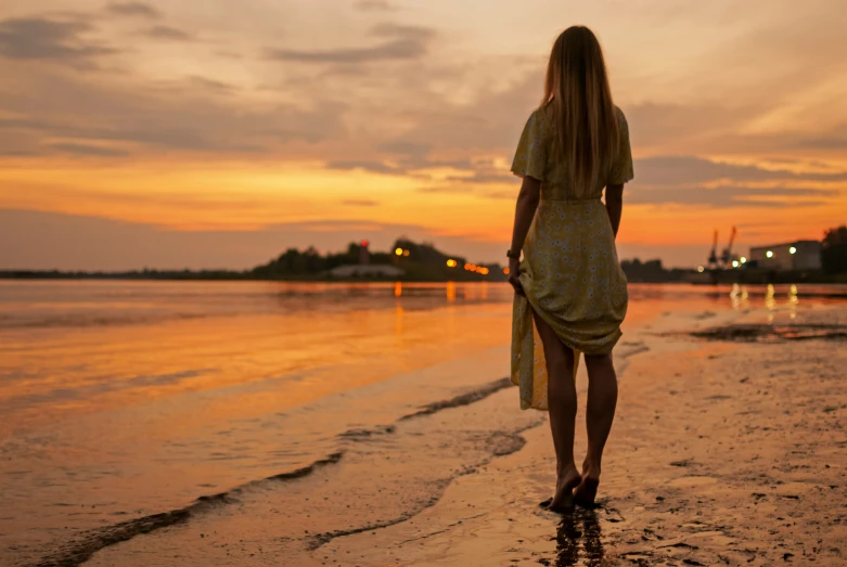 a woman is walking on the beach towards the water