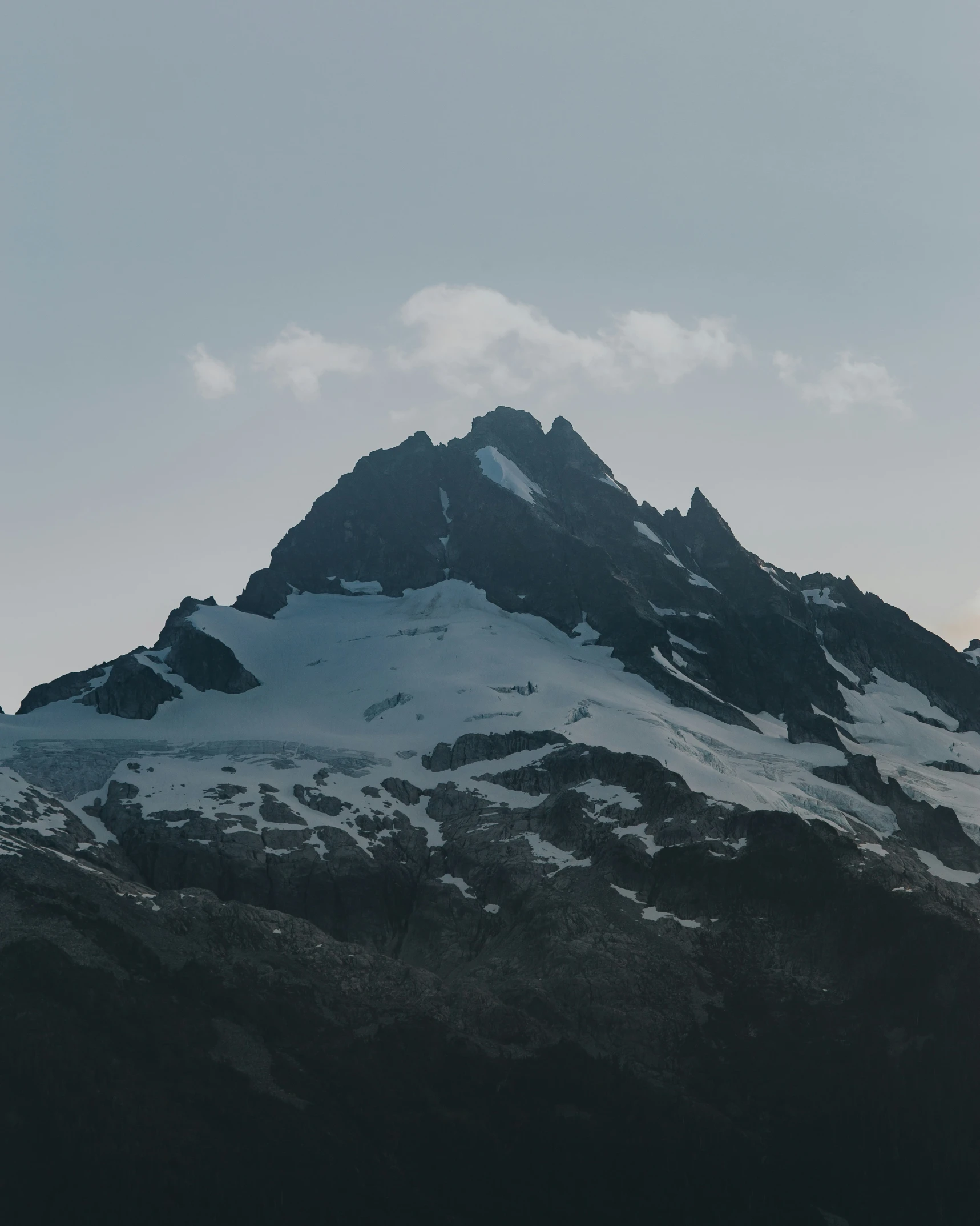 the snow covered mountains are covered in thick clouds