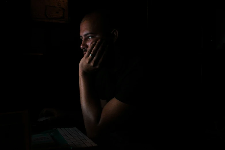 a man in the dark using a computer