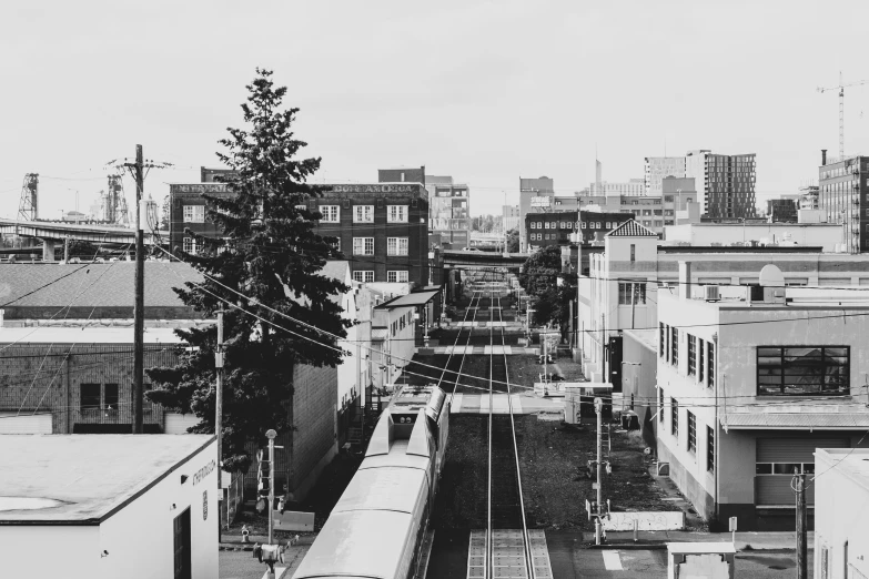 a black and white picture of a cityscape with trains on tracks