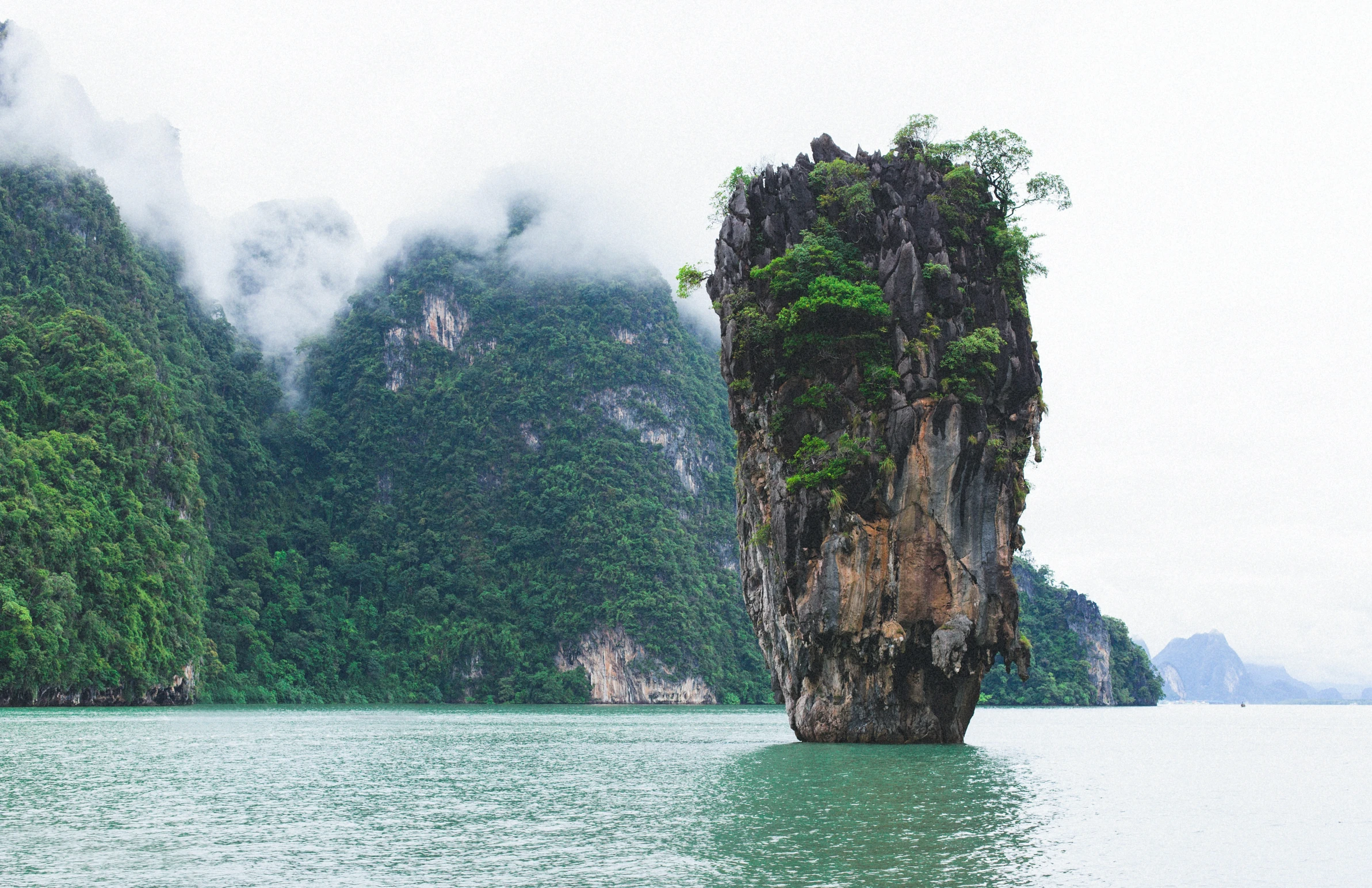 a large stone outcropping sitting in the middle of a body of water