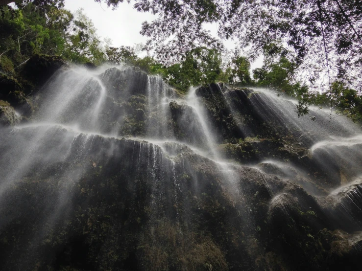 two long, cascaded waterfalls in a forest, one of which is falling down