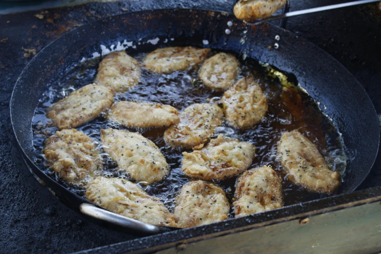 chicken is frying in a set with boiling oil
