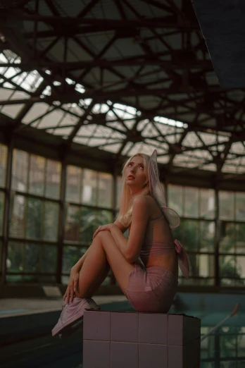 a blonde woman in pink lingerie sitting on top of a box