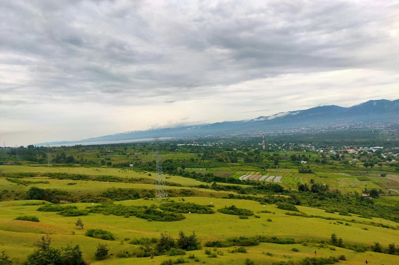 a view of a lush green countryside below clouds