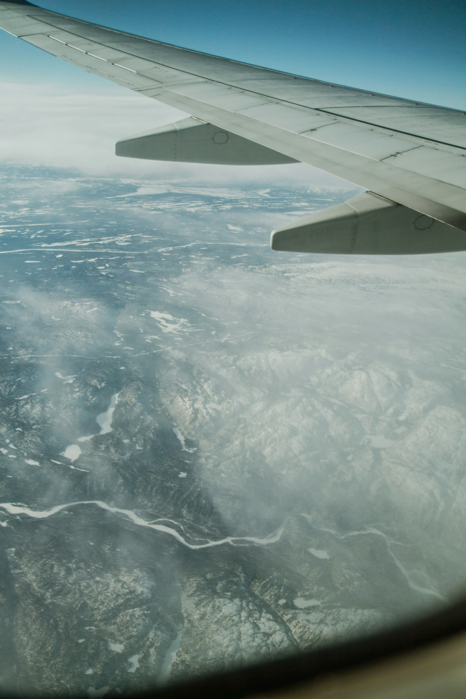 the wing of a plane flying over a river