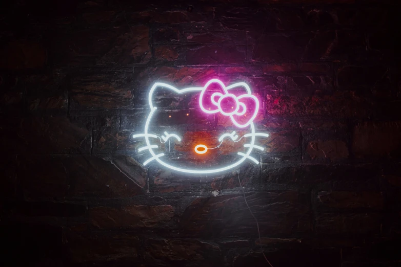 a neon hello kitty sign against a wall