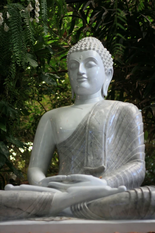 a small statue is sitting next to some trees