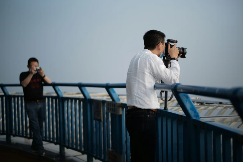 a man taking pictures on a bridge with his camera