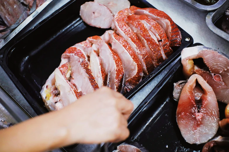 meats are being cooked in an open - sided frying pan