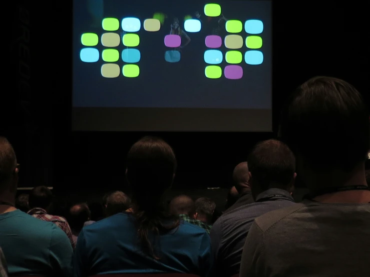 a group of people standing in front of a screen