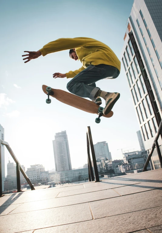 a young man in a yellow shirt riding a skateboard