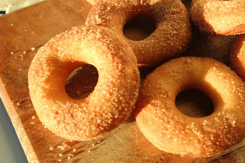 several glazed donuts piled together on top of a  board