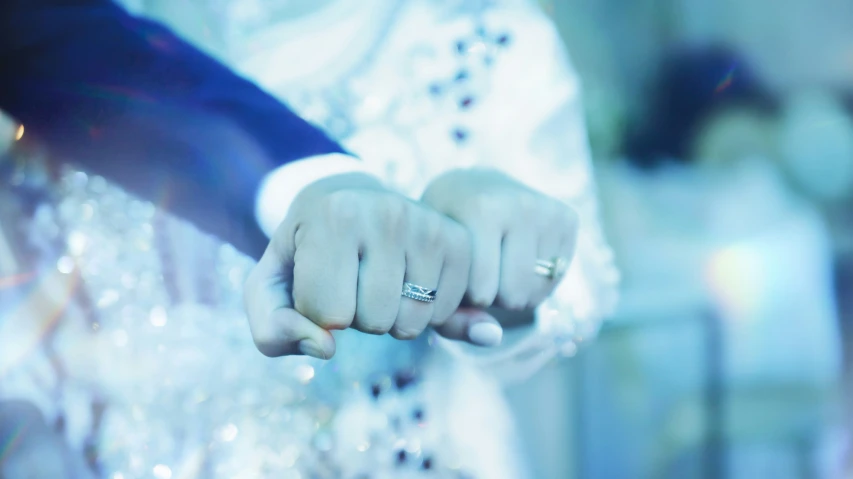 a close - up view of a person's hand holding a diamond ring