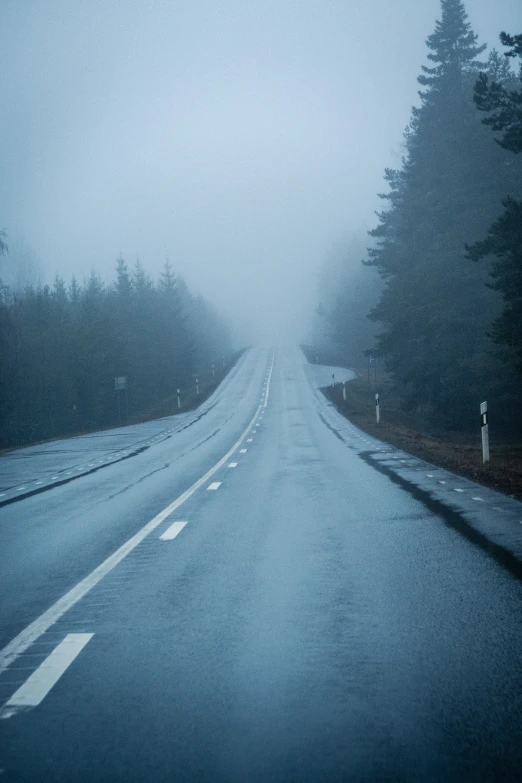 a car drives down the road with an approaching cloud